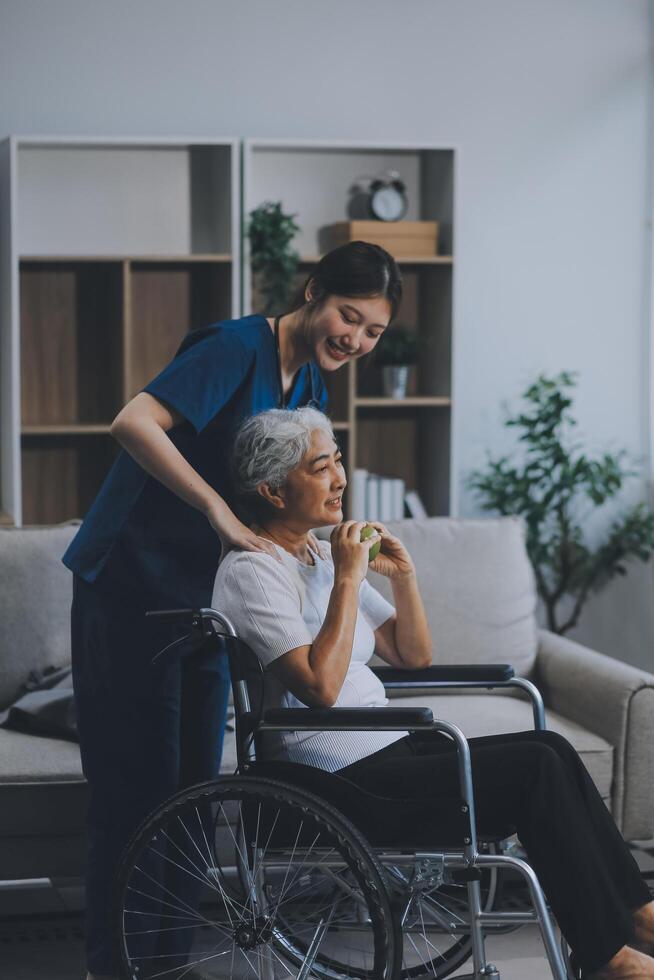 Asian physiotherapist helping elderly woman patient stretching arm during exercise correct with dumbbell in hand during training hand with patient Back problems in garden. Nursing home hospital photo