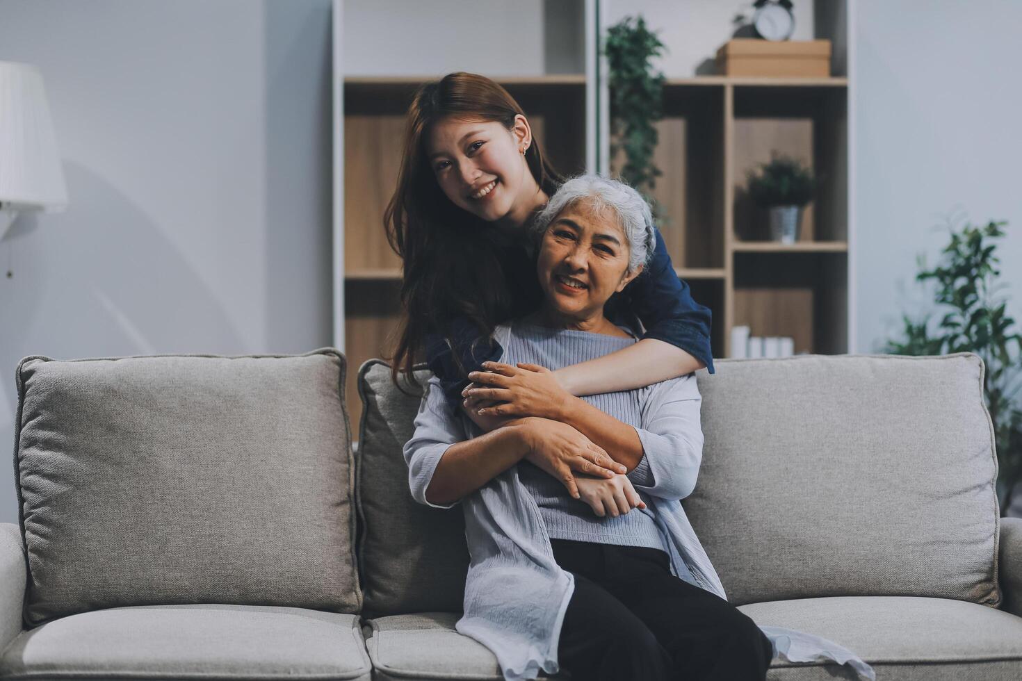 Adult daughter old mom hugging sit on couch enjoy pleasant positive talk, remembering funny occasion from life spend weekend together, caring about older generation relatives express attention concept photo