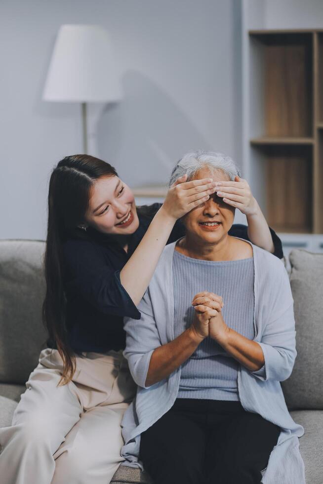 Adult daughter old mom hugging sit on couch enjoy pleasant positive talk, remembering funny occasion from life spend weekend together, caring about older generation relatives express attention concept photo