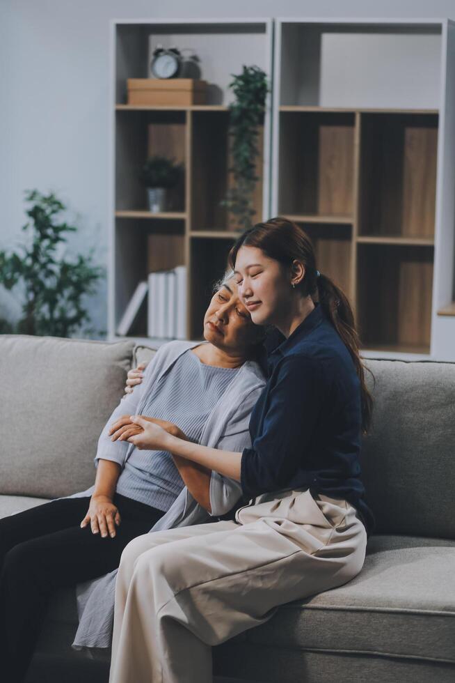Sad teen granddaughter hugging depressed mature grandmother, giving support, help, comforting, consoling granny. Teenage daughter girl and middle aged mother going through family problems photo