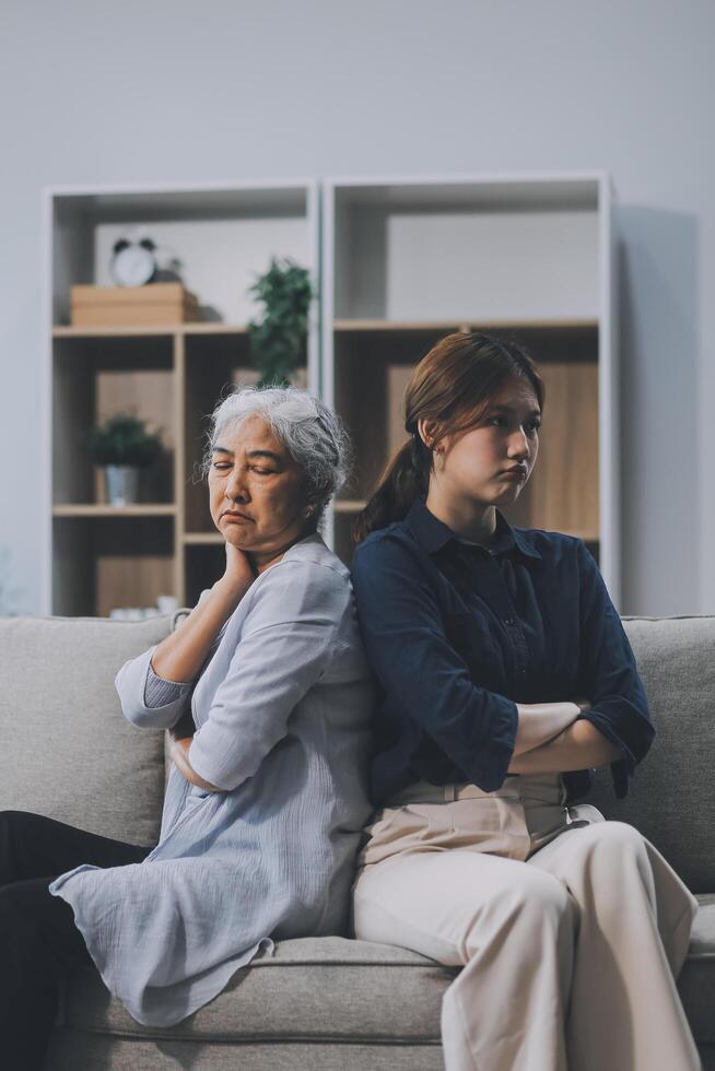 Sad teen granddaughter hugging depressed mature grandmother, giving support, help, comforting, consoling granny. Teenage daughter girl and middle aged mother going through family problems photo