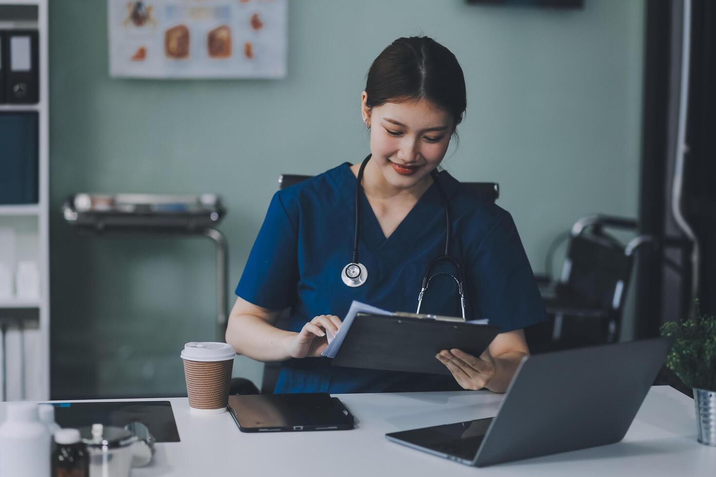 Female doctor writing in a notebook and holding a medicine bottle works at a computer while there were many medicine bottles on the table while sitting at a work desk photo