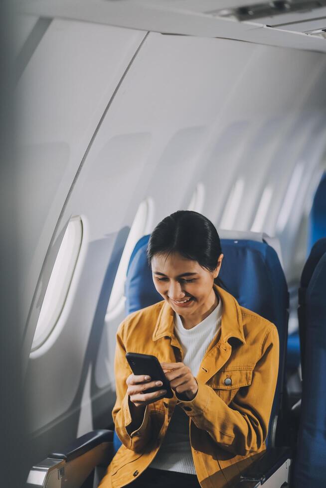 Texting on mobile chat app, Thoughtful asian people female person onboard, airplane window, perfectly capture the anticipation and excitement of holiday travel. chinese, japanese people. photo