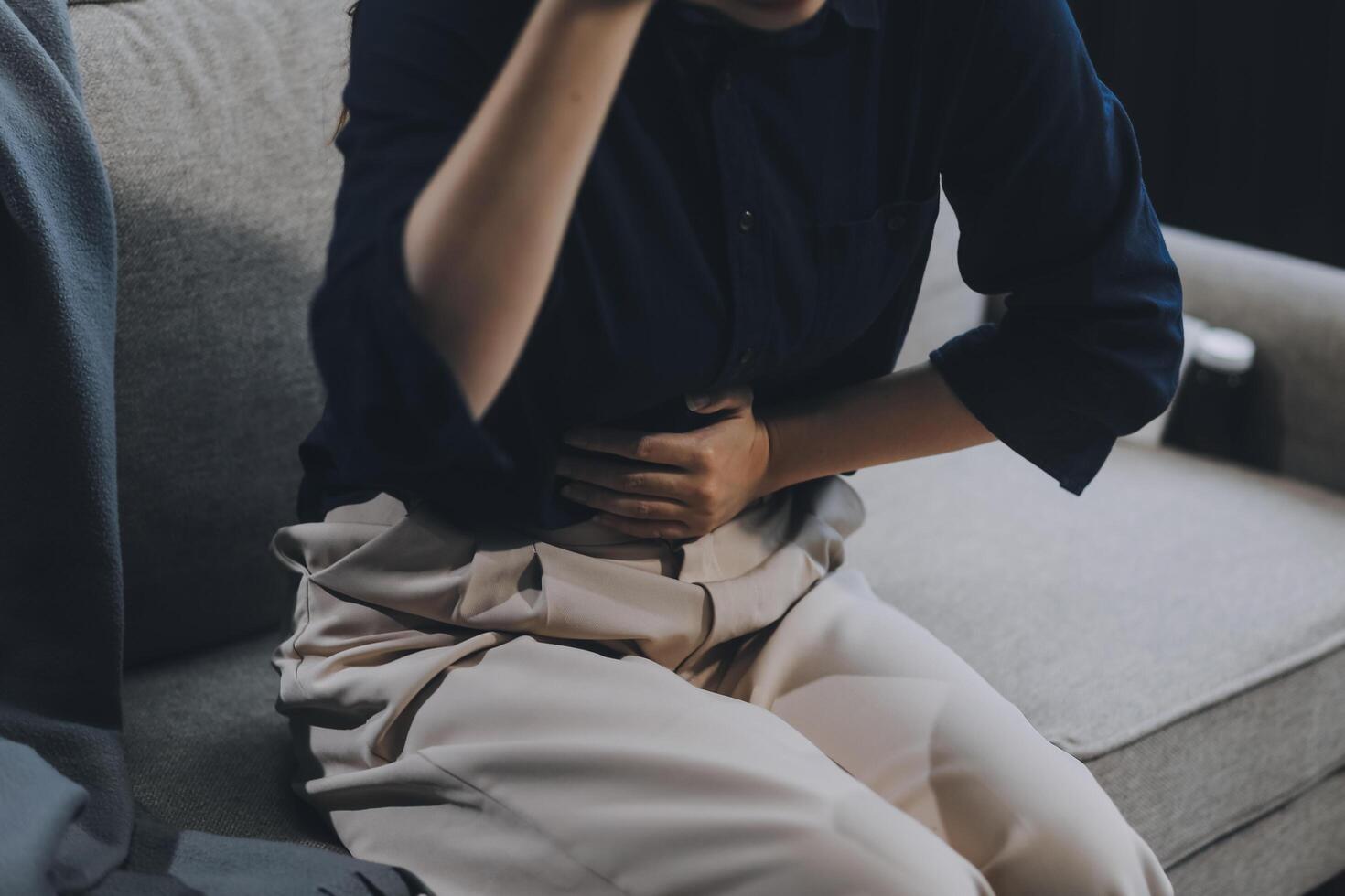 A woman with a cold with pills is treated at home chooses which drugs to take and self-medicates, checks the expiration date while sitting on the couch at home photo