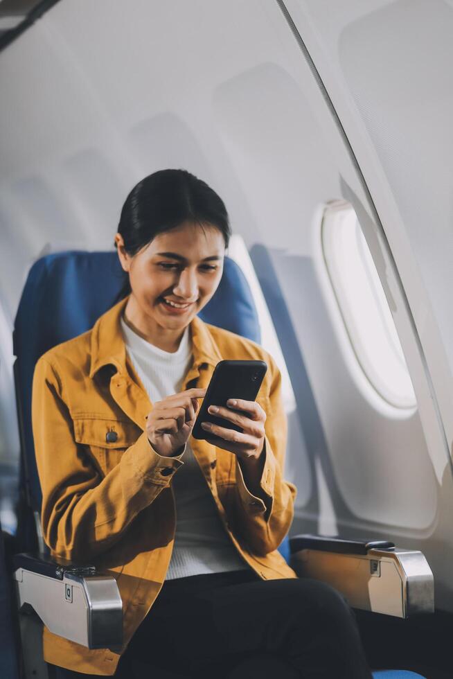 Texting on mobile chat app, Thoughtful asian people female person onboard, airplane window, perfectly capture the anticipation and excitement of holiday travel. chinese, japanese people. photo