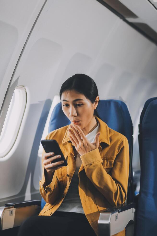Texting on mobile chat app, Thoughtful asian people female person onboard, airplane window, perfectly capture the anticipation and excitement of holiday travel. chinese, japanese people. photo