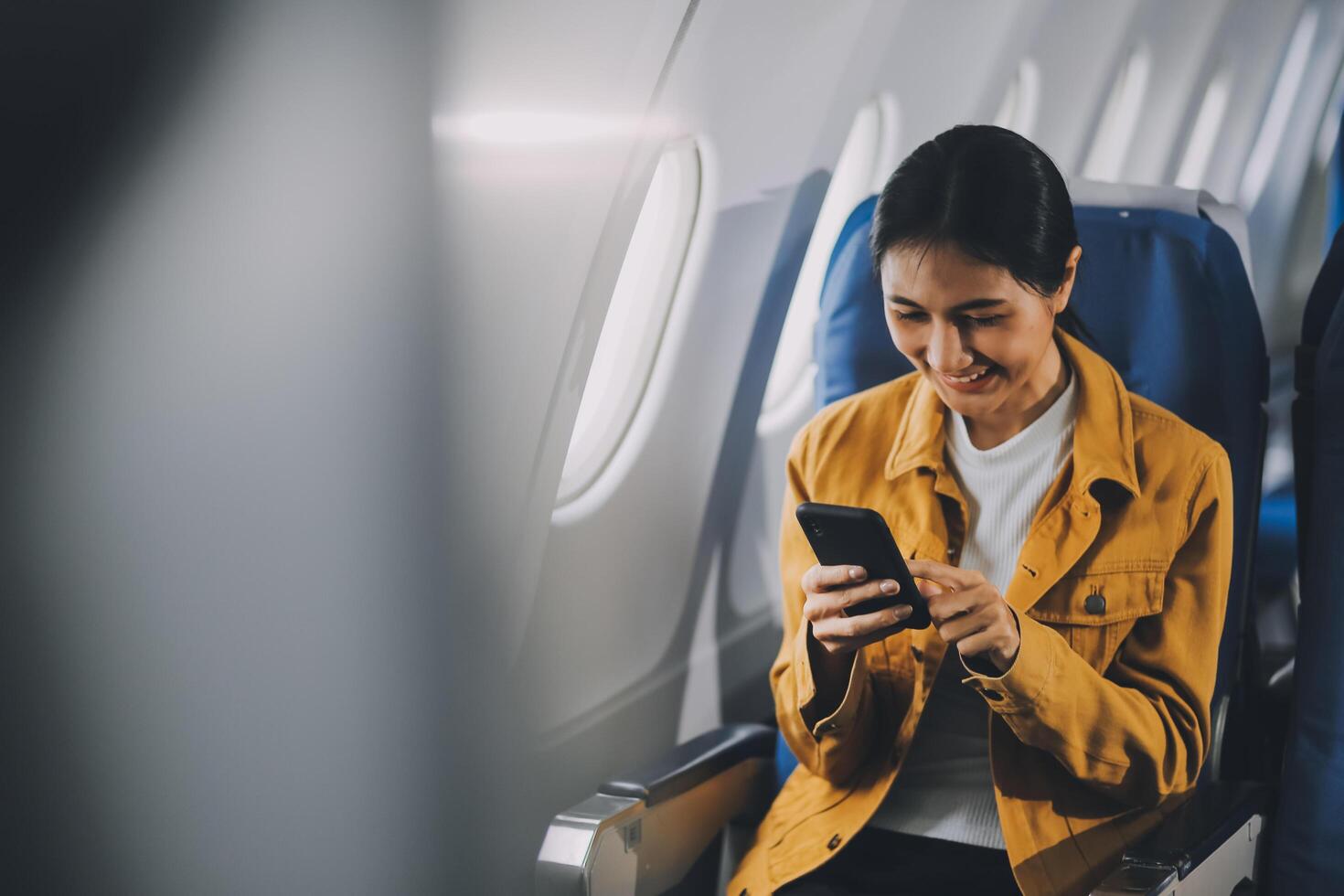 Texting on mobile chat app, Thoughtful asian people female person onboard, airplane window, perfectly capture the anticipation and excitement of holiday travel. chinese, japanese people. photo