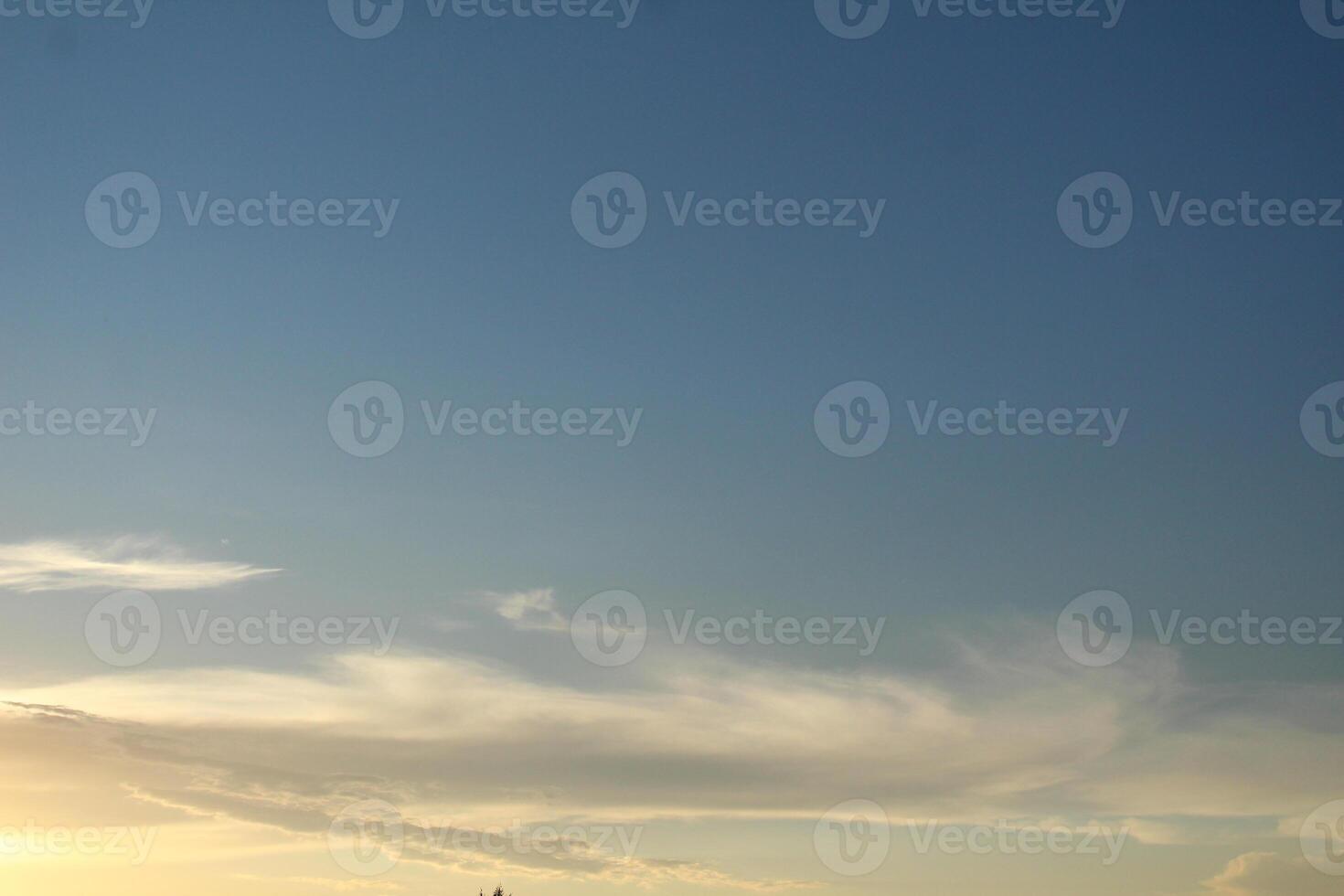 Cloudy Blue Sky in the evening light. Evening light blue sky with white clouds photo