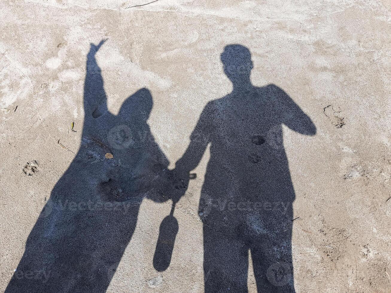 silhouette or shadow of a pair of lovers on the beach sand photo