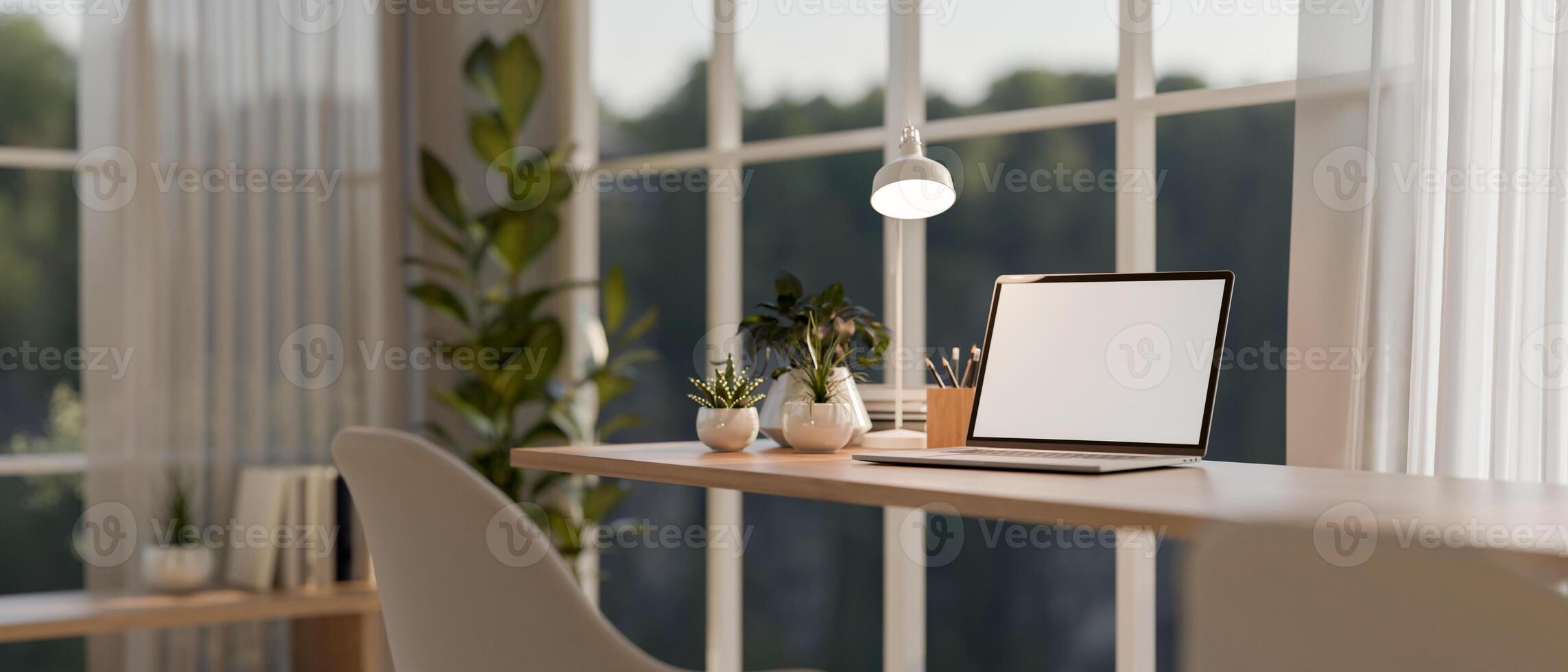 A laptop computer on a wooden table against the window in a contemporary minimalist room. photo