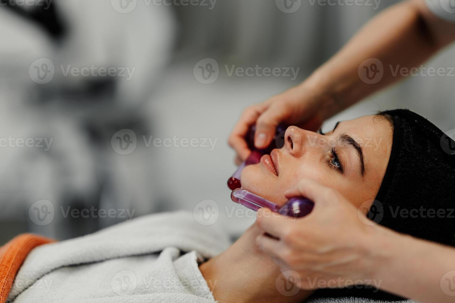 The master gives the client a relaxing facial massage using cold cryo spheres. photo