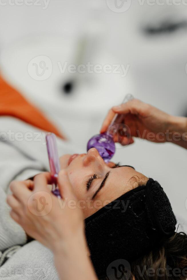 The master gives the client a relaxing facial massage using cold cryo spheres. photo