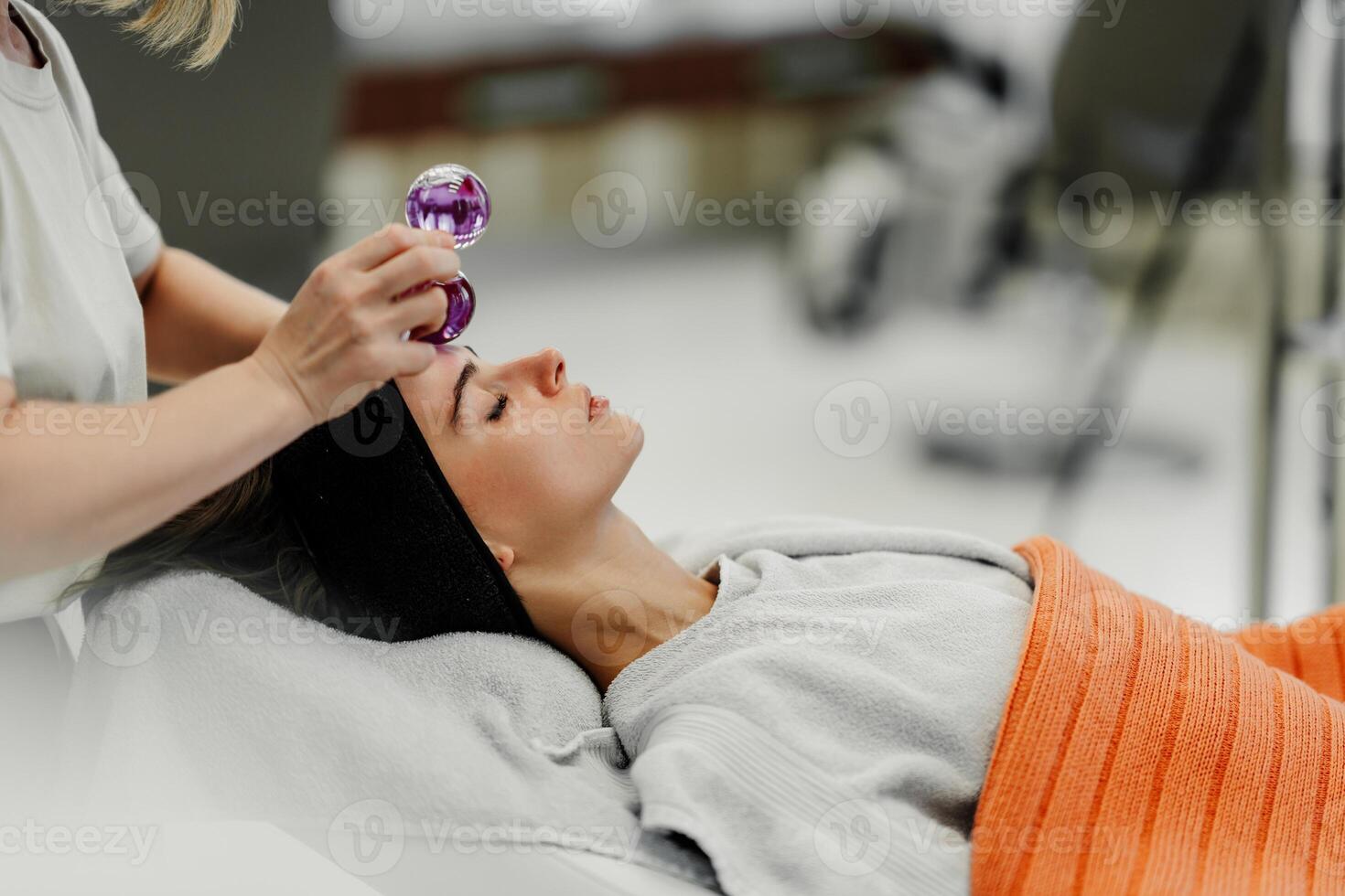 The master gives the client a relaxing facial massage using cold cryo spheres. photo