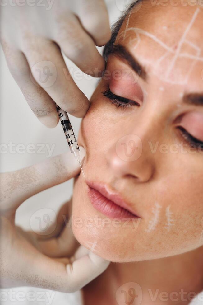 A woman gets injections in the face. photo