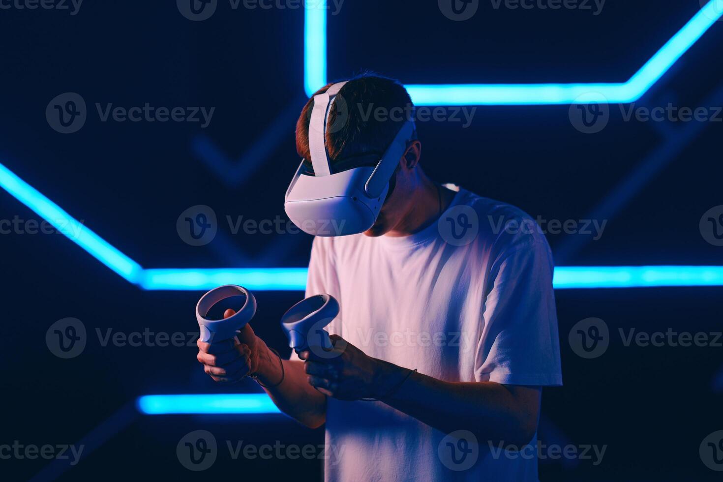A man plays a VR game in a neon room. photo