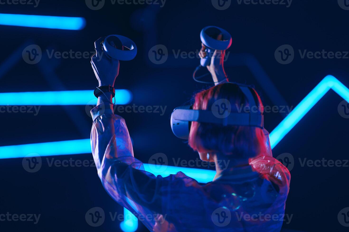 Young woman playing VR game in neon room. photo
