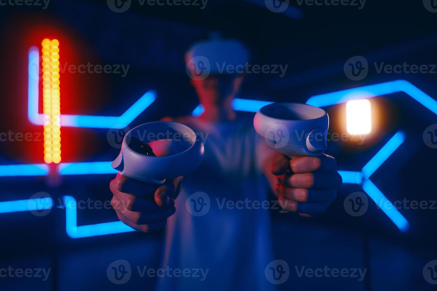 A man plays a VR game in a neon room. photo