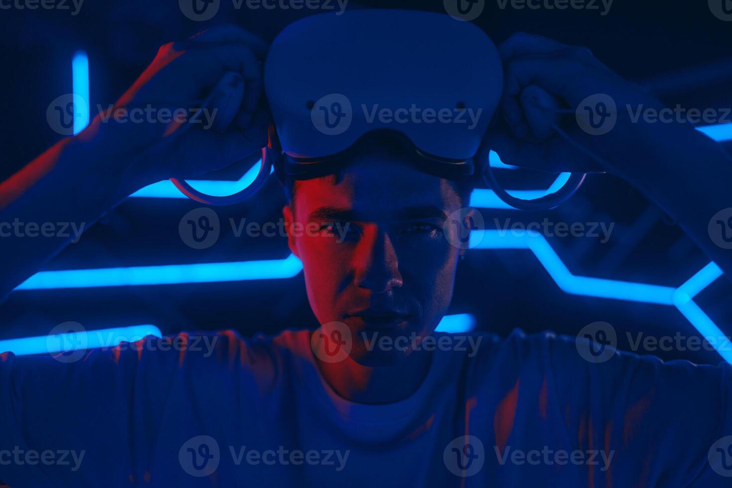 A man plays a VR game in a neon room. photo