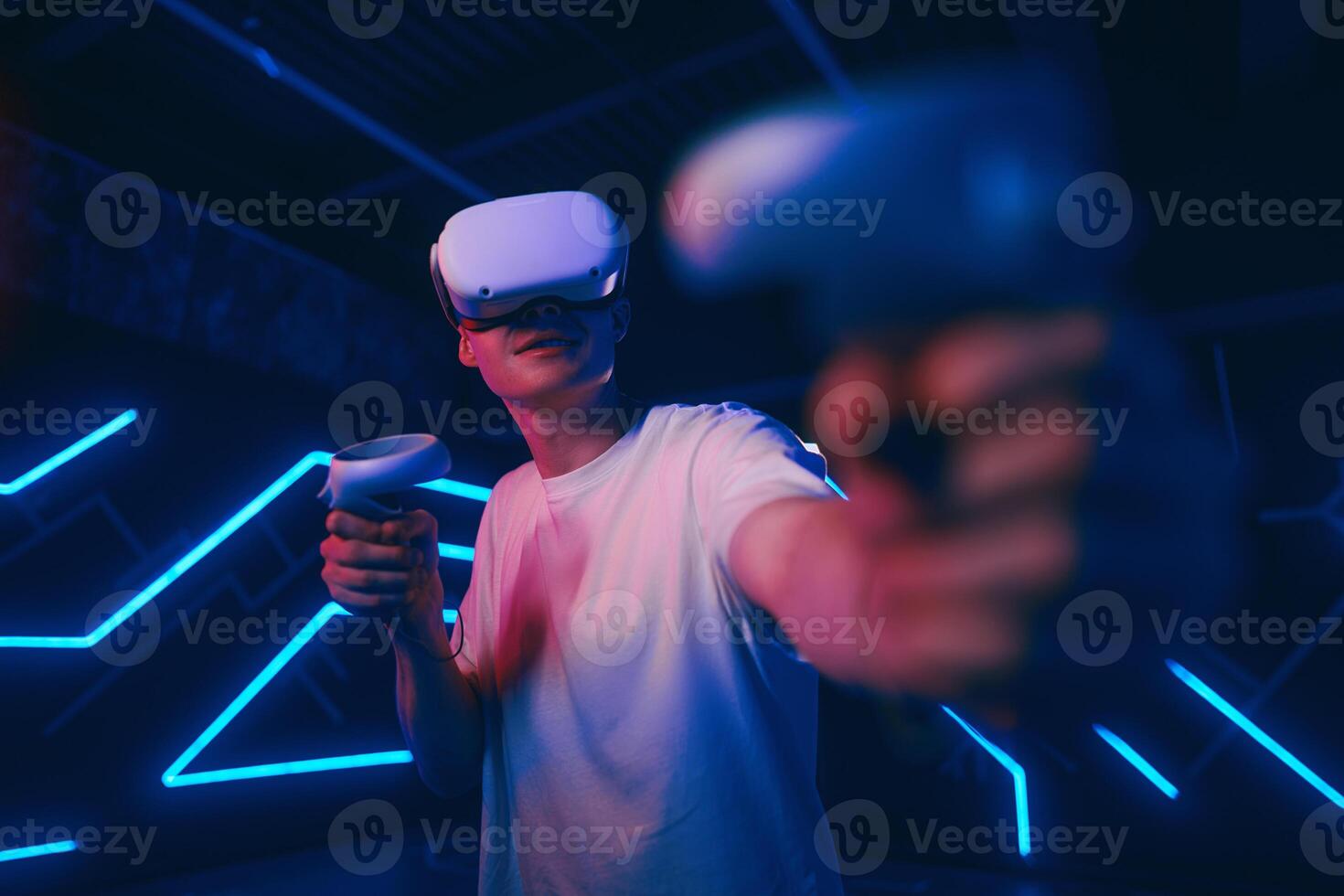 A man plays a VR game in a neon room. photo