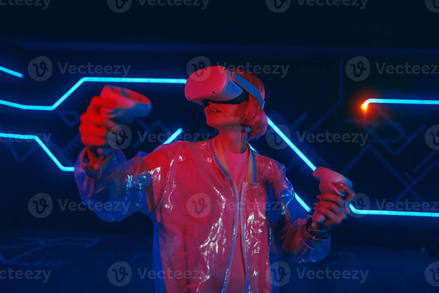 A young woman plays virtual games. Neon room for vr games. photo
