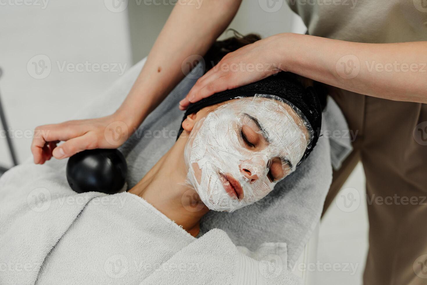 Professional facial skin care. A master massages a woman's face in a beauty salon. photo