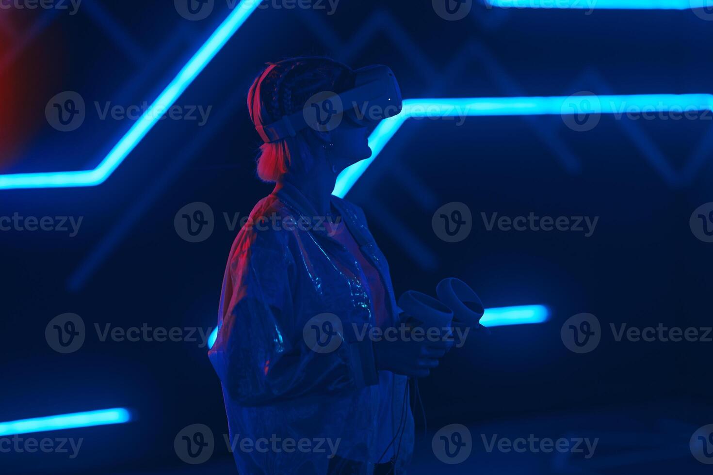 Young woman playing VR game in neon room. photo
