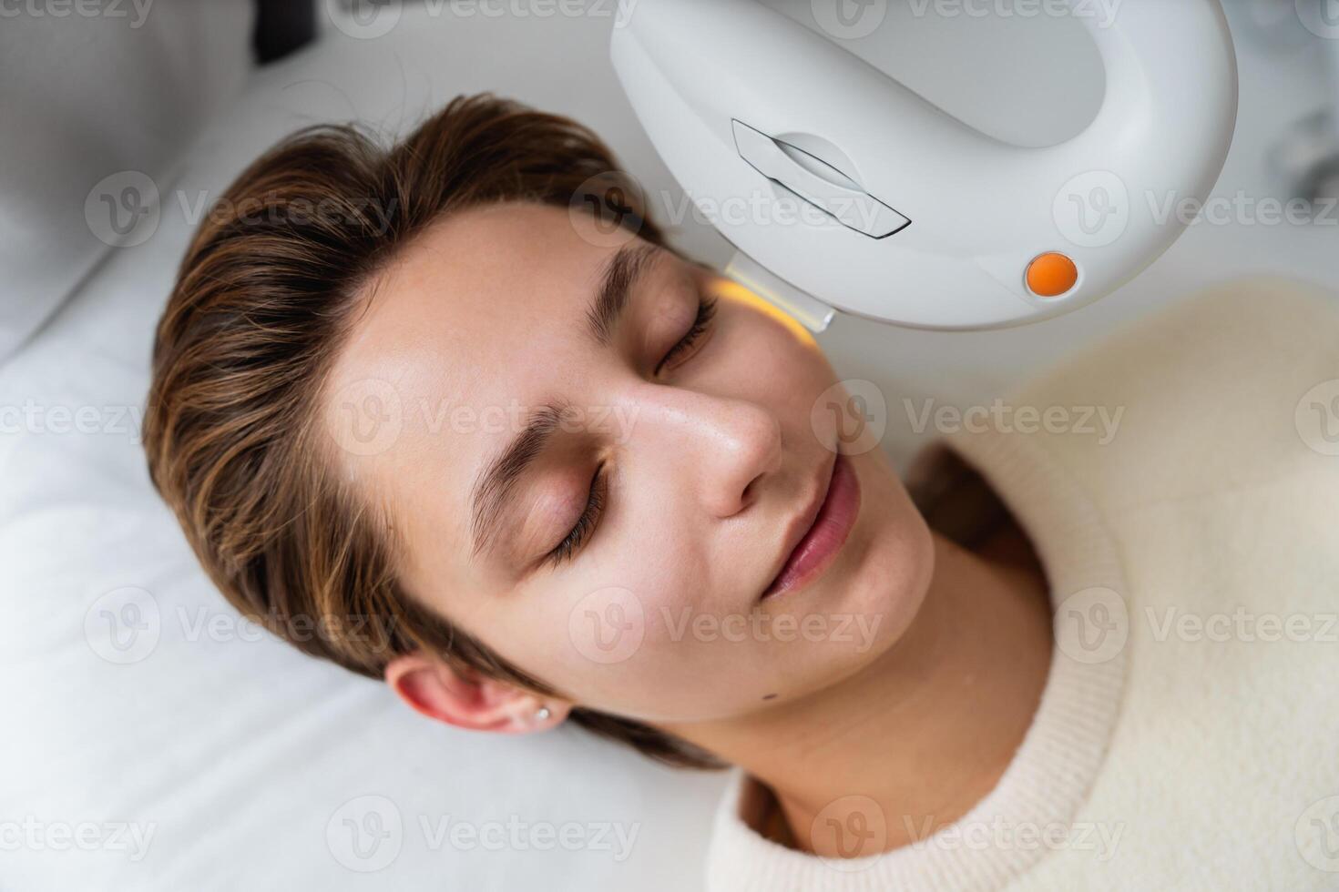 Phototherapy, photorejuvenation, IPL in a beauty salon. Care for a woman's face. photo