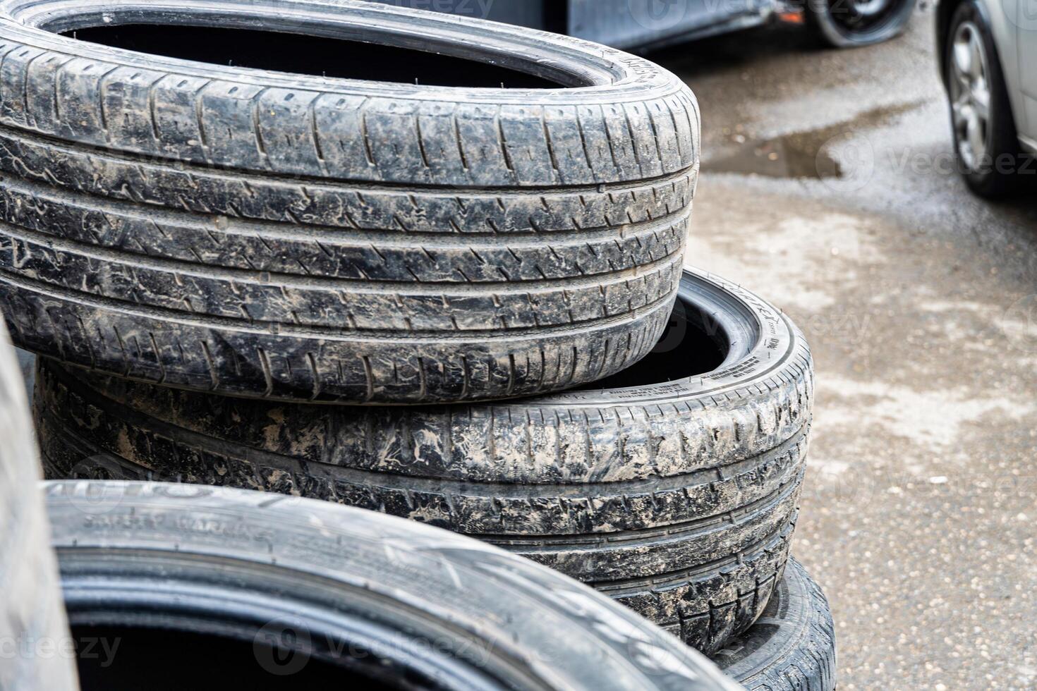 Used Tires Stacked on Pavement photo