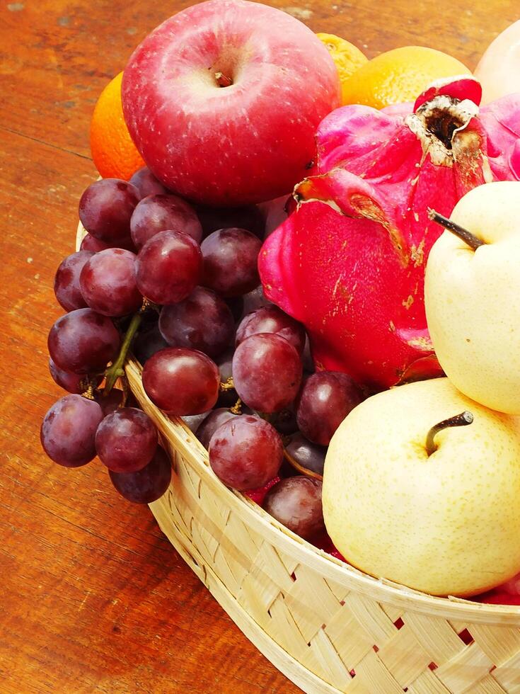 mix fruit on wooden basket grape apple pear orange. Harvesting from fruit garden into fruit store photo