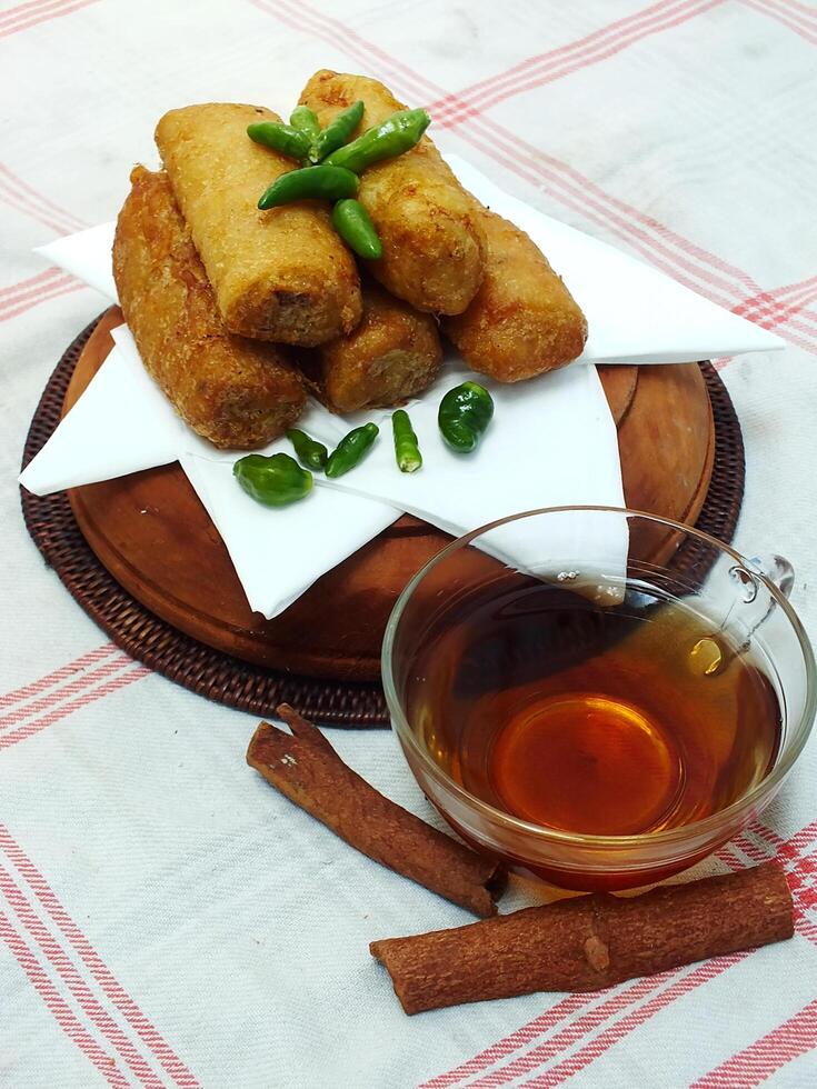 Traditional Indonesian snack Sosis Solo from Central Java, made from savory flour dough and filled with delicious minced chicken or beef then fried. More delicious if eaten with green cayenne pepper photo