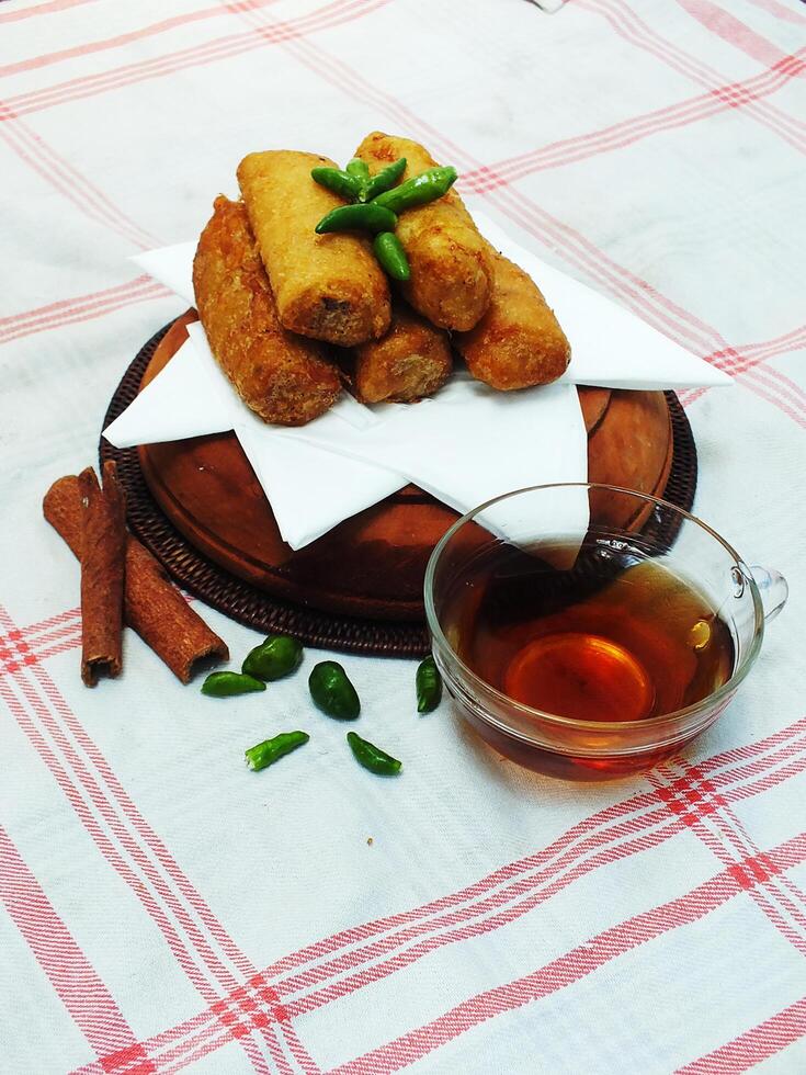 Traditional Indonesian snack Sosis Solo from Central Java, made from savory flour dough and filled with delicious minced chicken or beef then fried. More delicious if eaten with green cayenne pepper photo