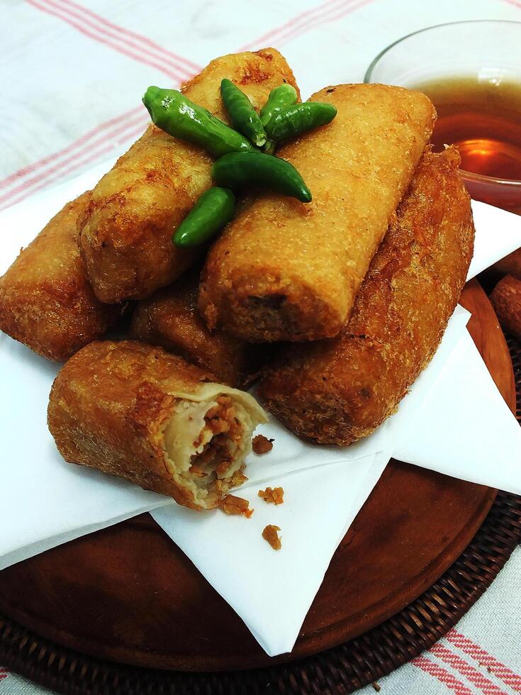 Traditional Indonesian snack Sosis Solo from Central Java, made from savory flour dough and filled with delicious minced chicken or beef then fried. More delicious if eaten with green cayenne pepper photo