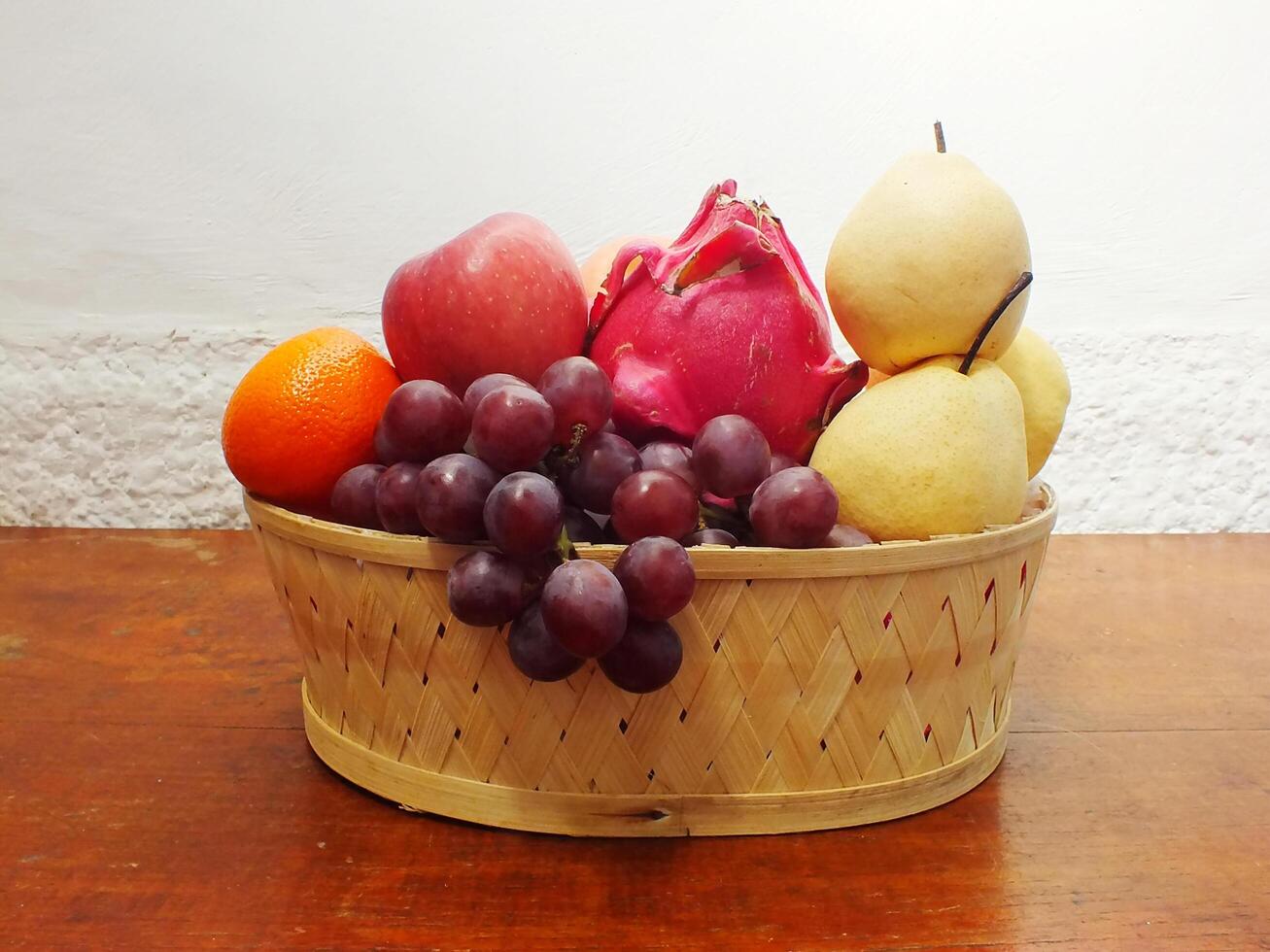 mix fruit on wooden basket grape apple pear orange. Harvesting from fruit garden into fruit store photo