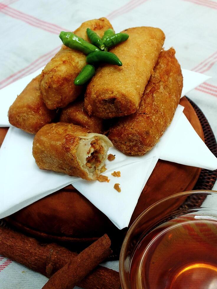 Traditional Indonesian snack Sosis Solo from Central Java, made from savory flour dough and filled with delicious minced chicken or beef then fried. More delicious if eaten with green cayenne pepper photo