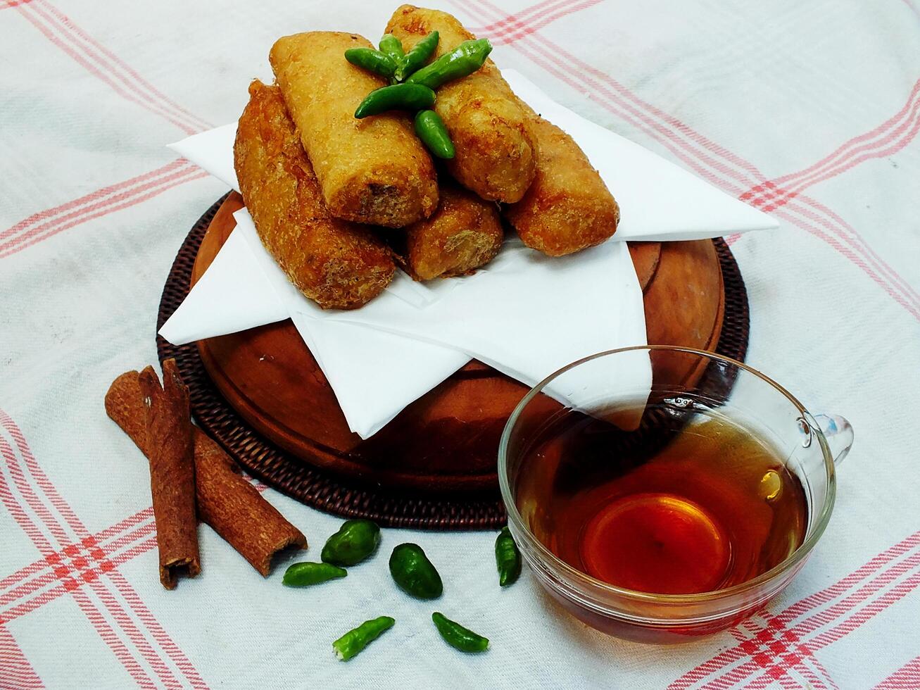 Traditional Indonesian snack Sosis Solo from Central Java, made from savory flour dough and filled with delicious minced chicken or beef then fried. More delicious if eaten with green cayenne pepper photo
