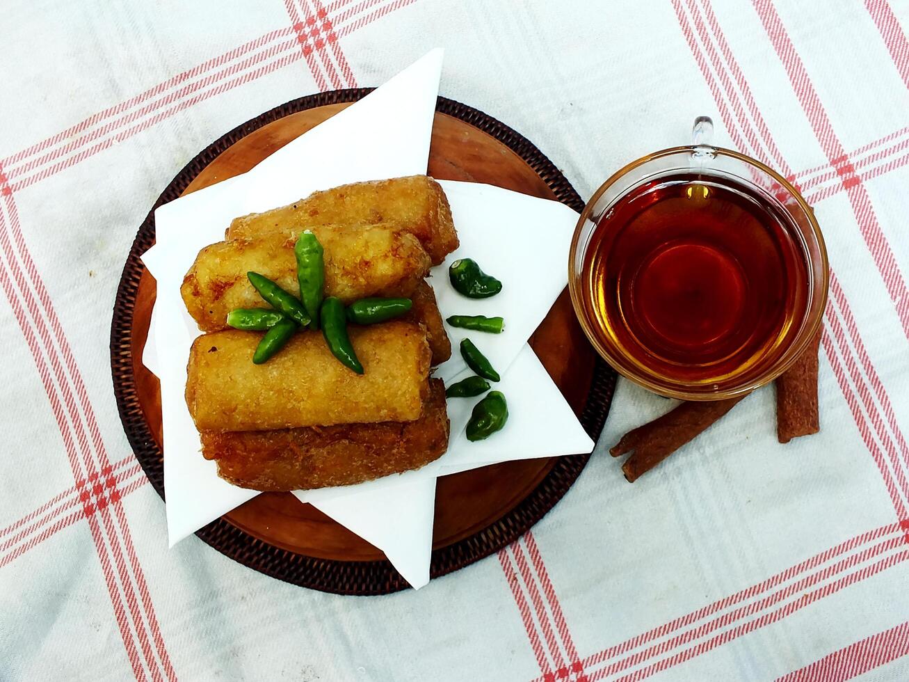 Traditional Indonesian snack Sosis Solo from Central Java, made from savory flour dough and filled with delicious minced chicken or beef then fried. More delicious if eaten with green cayenne pepper photo