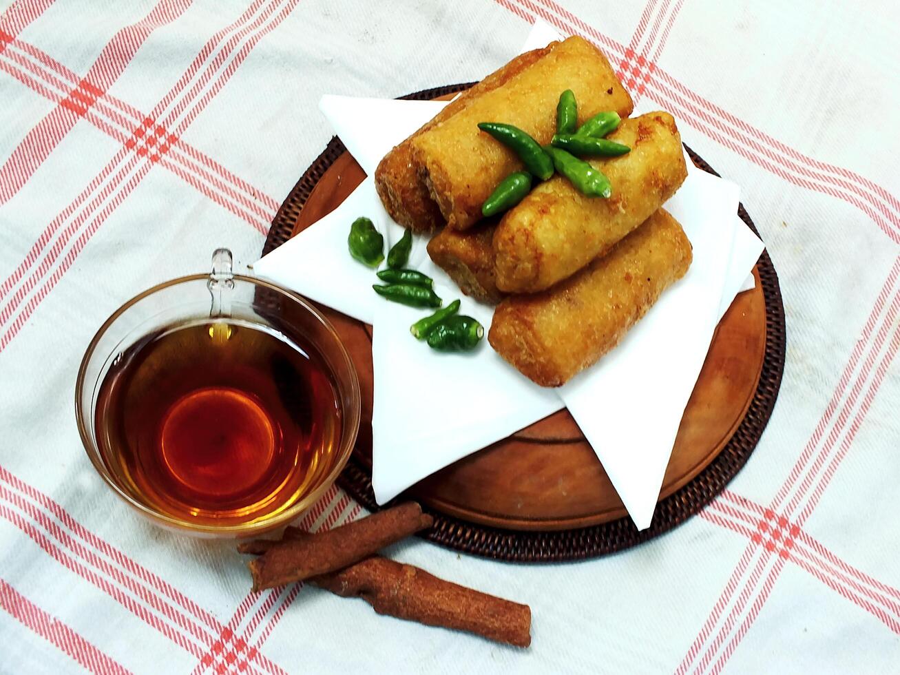 Traditional Indonesian snack Sosis Solo from Central Java, made from savory flour dough and filled with delicious minced chicken or beef then fried. More delicious if eaten with green cayenne pepper photo