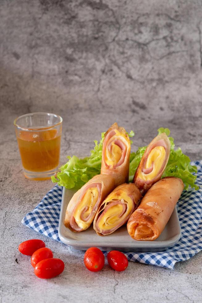 Deep fried spring rolls with ham and cheese on table as appetizer for big meal photo