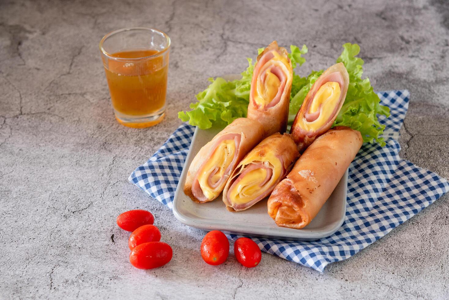 Deep fried spring rolls with ham and cheese on table as appetizer for big meal photo