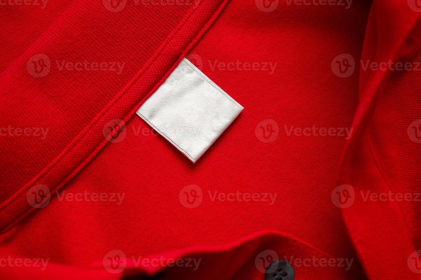 Blank white laundry care clothes label on red shirt fabric texture background photo