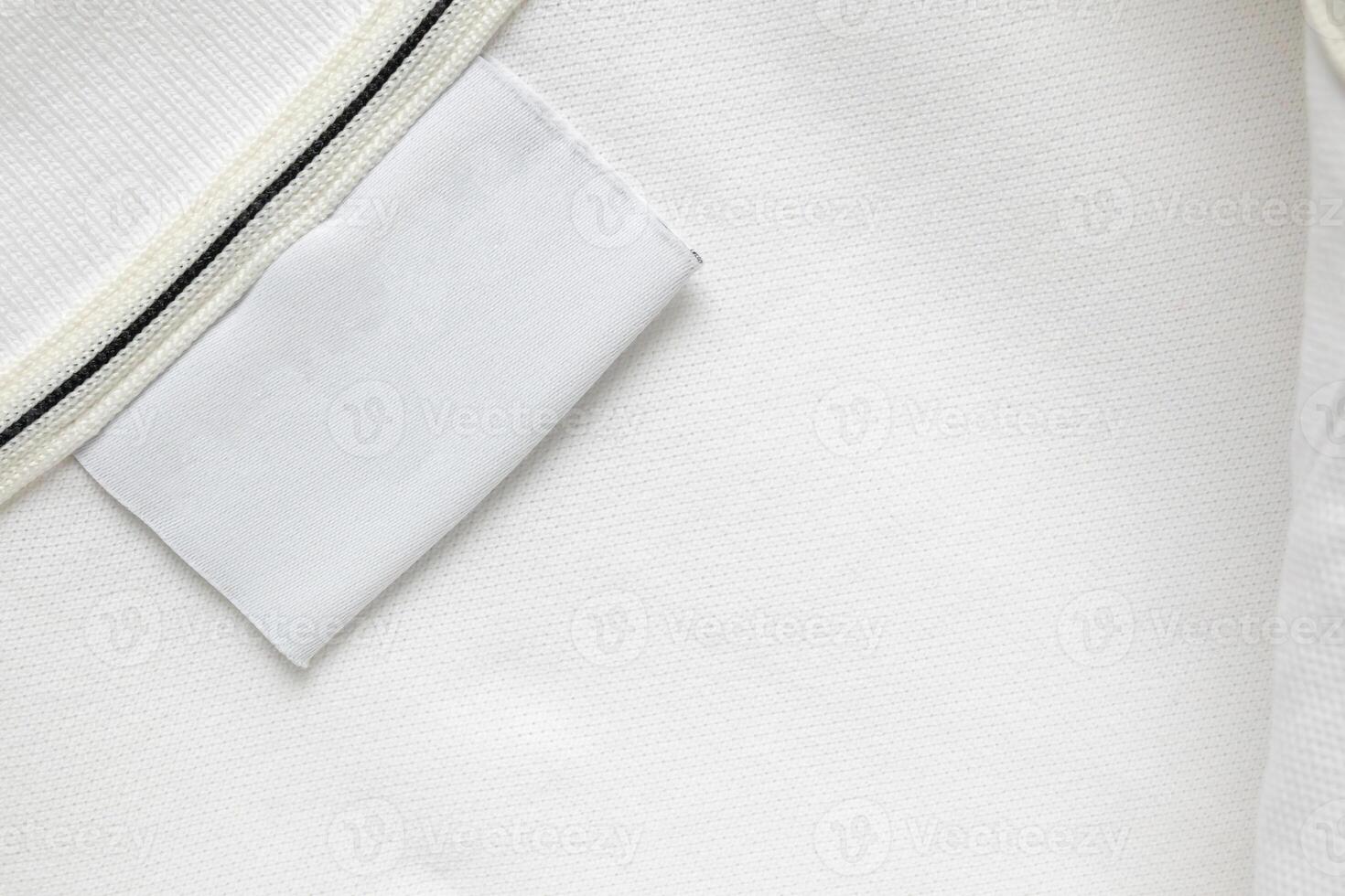 Blank white laundry care clothes label on white shirt fabric texture background photo