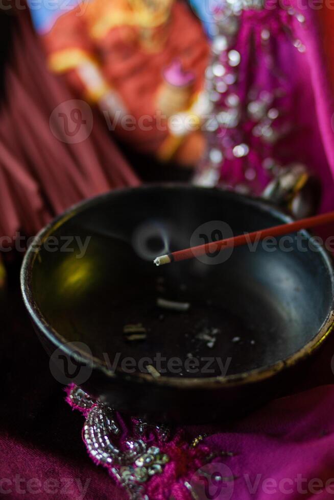 An incense stick smolders in a trickle of smoke photo