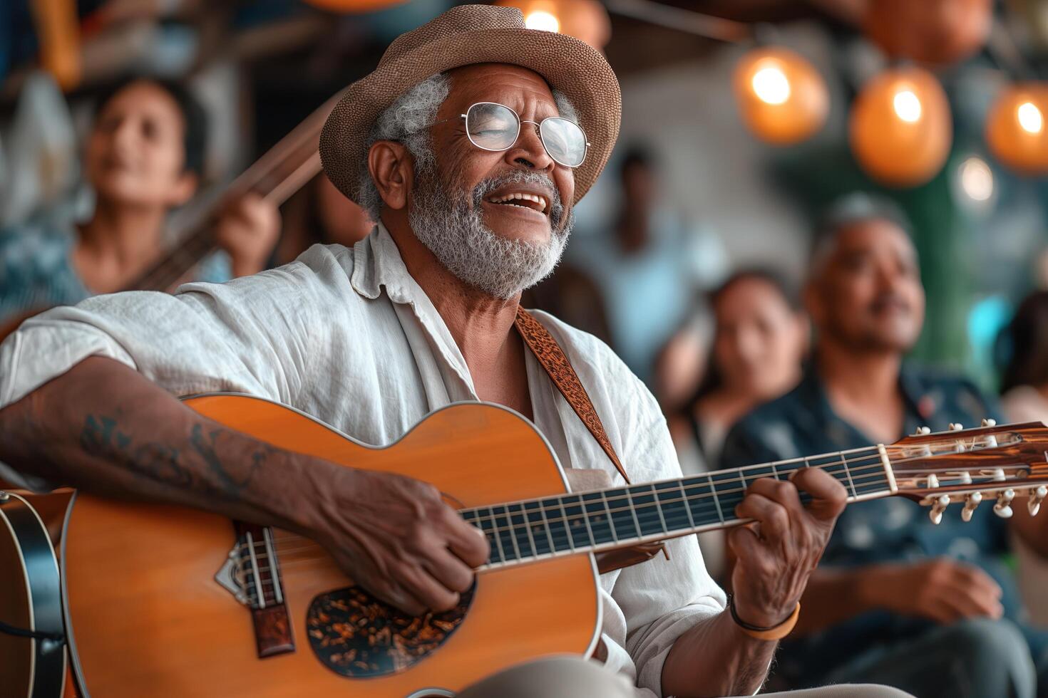 Photo of a man playing the guitar and singing, surrounded by a group of friends
