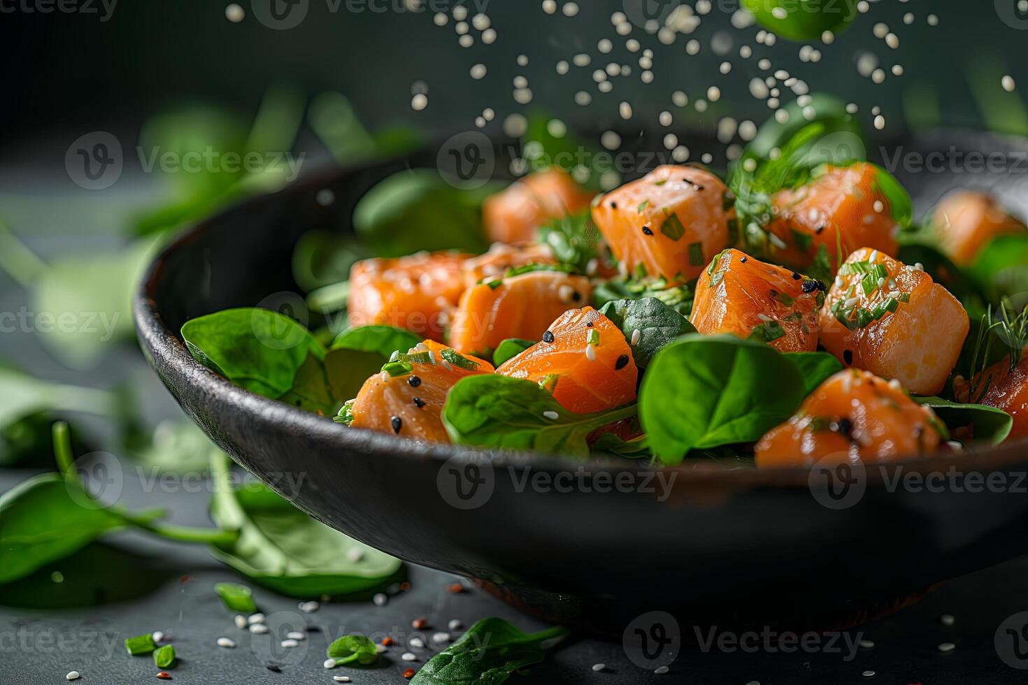 Salad in a black plate of salmon, spinach, on a black background photo