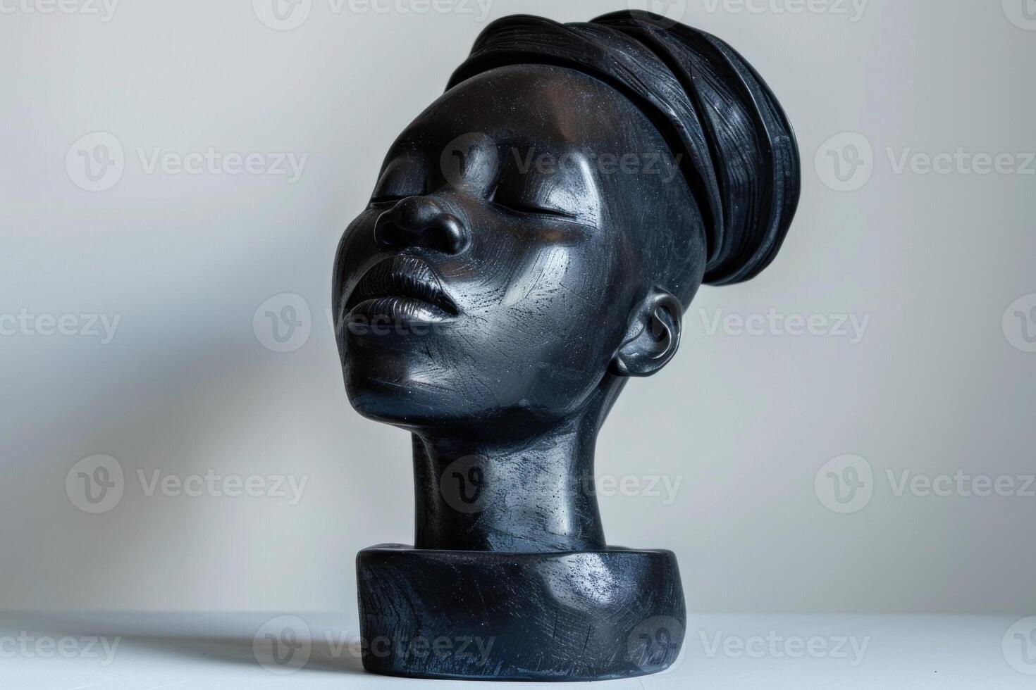 Black wooden sculpture depicting a woman with eyes closed photo