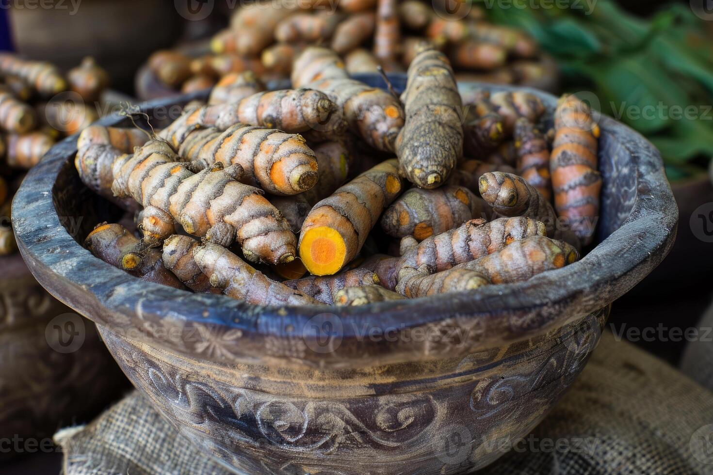 Fresh turmeric root displayed in a wooden bowl at the market photo