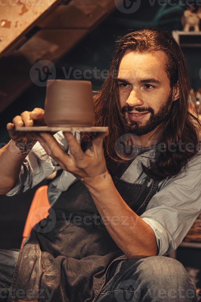 clay cup mug handcrafted man artist happy working proud look at finished hand craft product ceramic tea mug art project at workshop photo