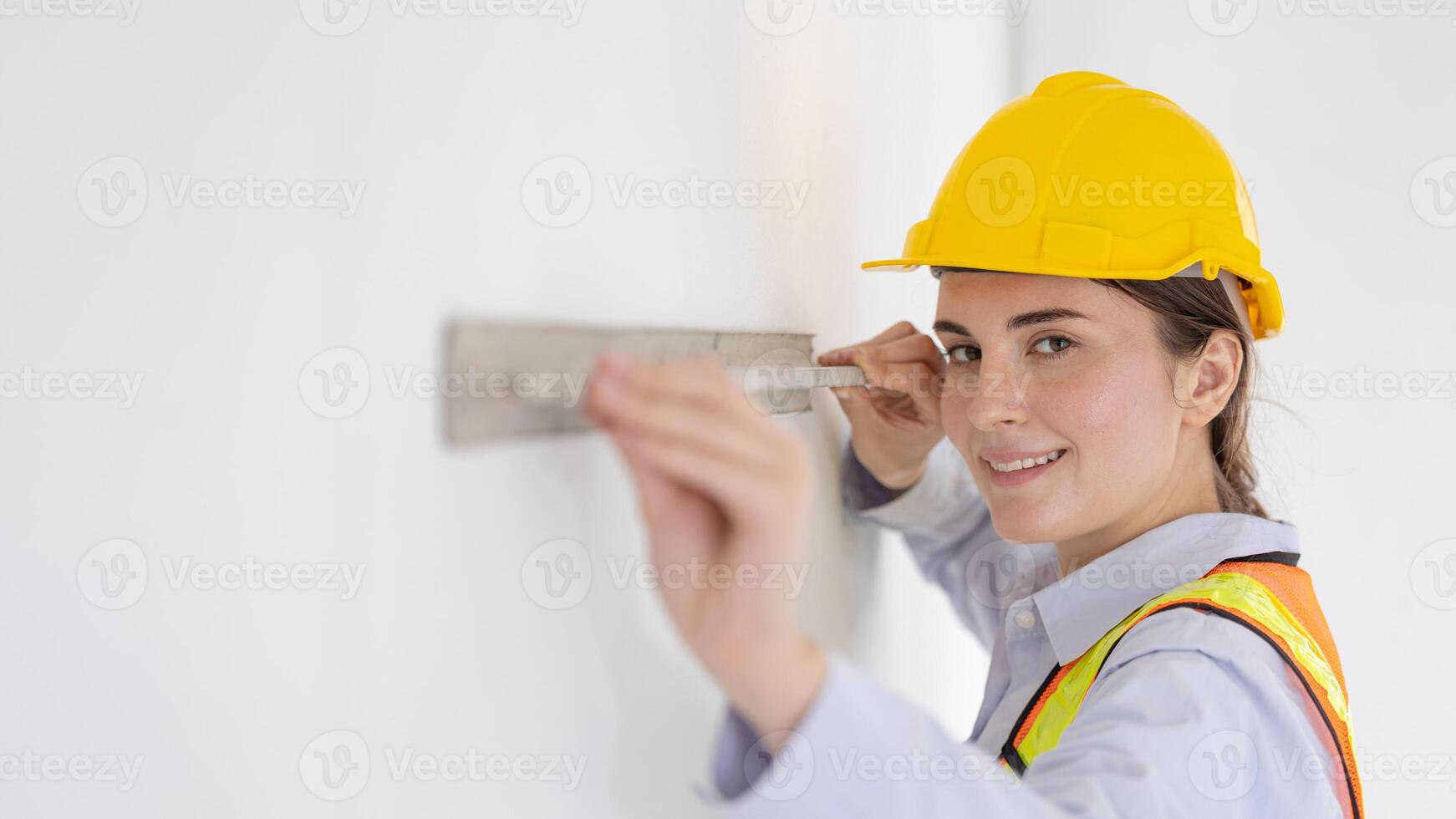 Beauty women construction worker model with Cement wall Plastering Tool looking camera happy smiling photo