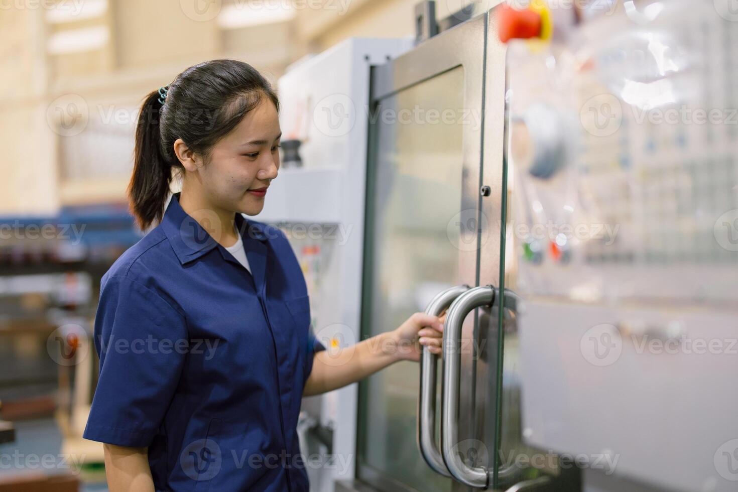 young technician engineer worker women working with CNC lathe metal machine in modern steel industry factory photo