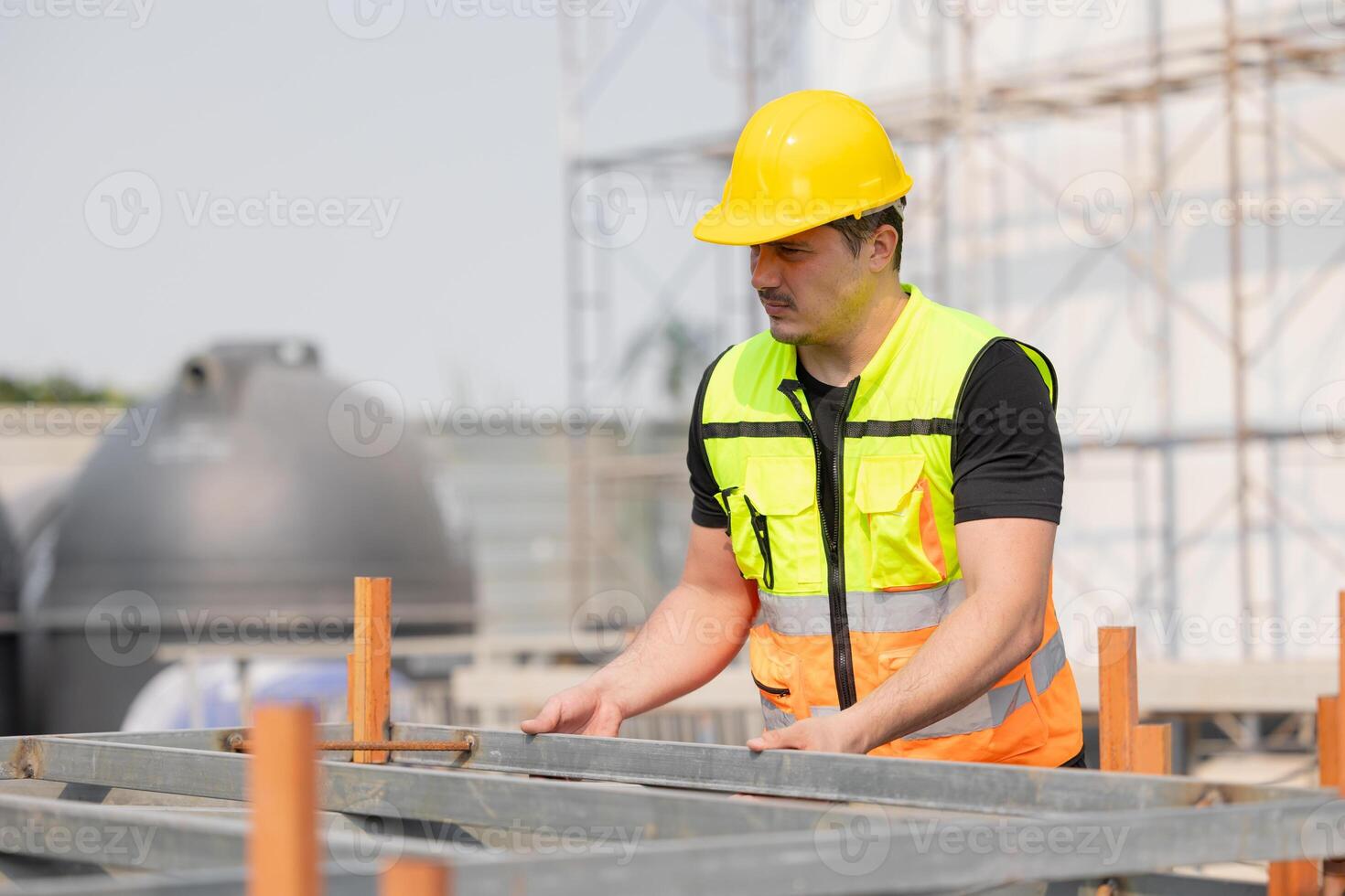 Construction Worker Wearing Hard Hat and Safety Vest Check Inspecting Build Steel Square Tube photo